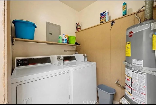 washroom with gas water heater, washing machine and dryer, and electric panel