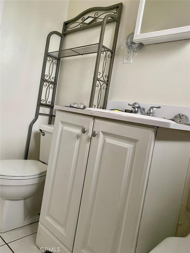 bathroom with toilet, tile patterned flooring, and vanity