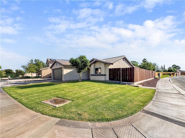 view of side of property with driveway, stucco siding, fence, a yard, and a garage
