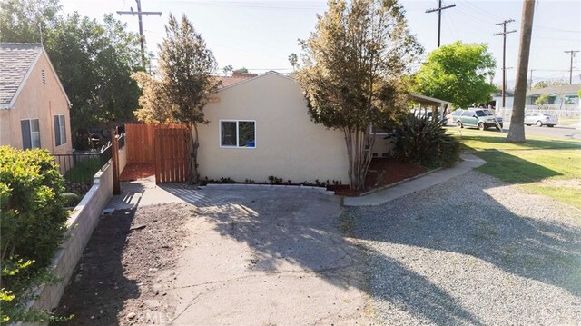view of home's exterior with fence and stucco siding