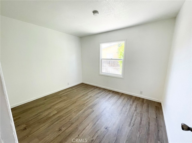 unfurnished room featuring wood finished floors and baseboards