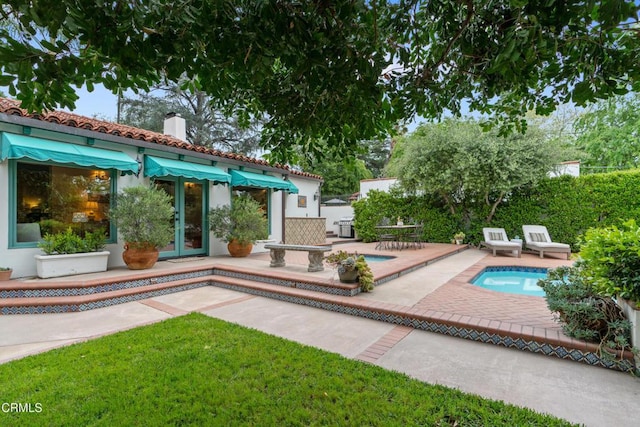 exterior space with a patio area, an outdoor pool, a chimney, stucco siding, and french doors