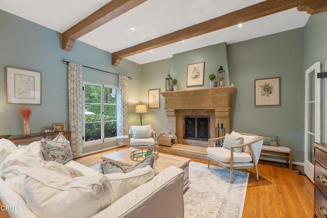 living room featuring beamed ceiling, recessed lighting, a high end fireplace, and wood finished floors