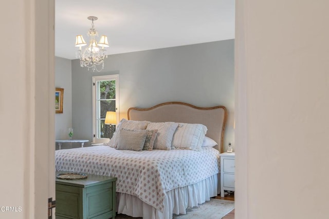 bedroom with wood finished floors and a chandelier