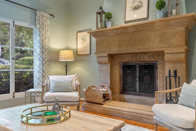 sitting room with a fireplace and wood finished floors