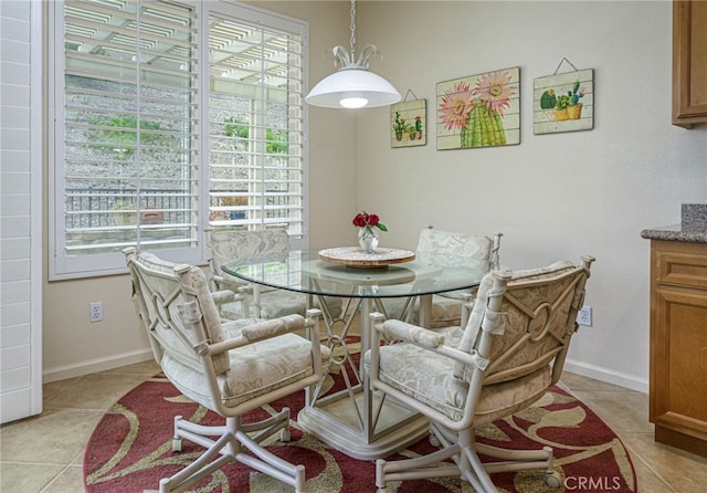 dining area featuring light tile patterned floors, plenty of natural light, and baseboards