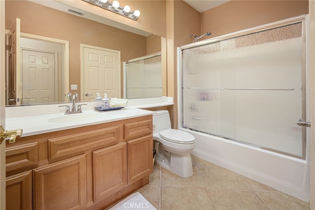 full bath with bath / shower combo with glass door, visible vents, toilet, tile patterned floors, and vanity