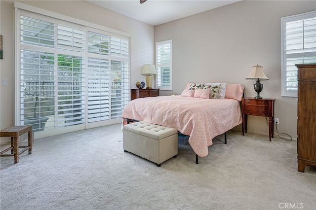 carpeted bedroom featuring a ceiling fan and access to exterior