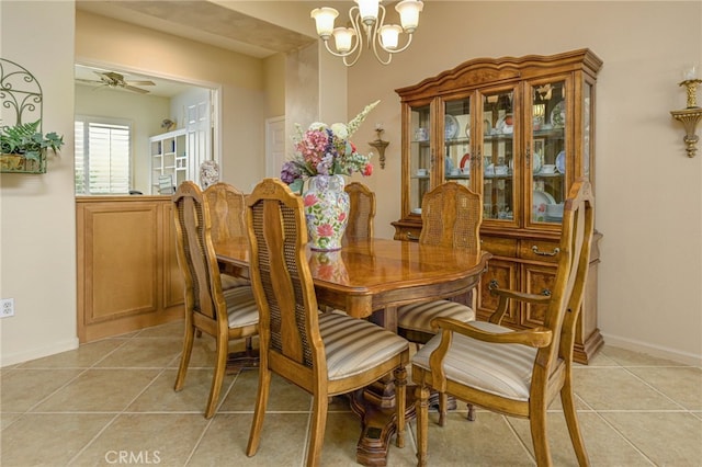 dining space featuring baseboards, ceiling fan with notable chandelier, and light tile patterned flooring