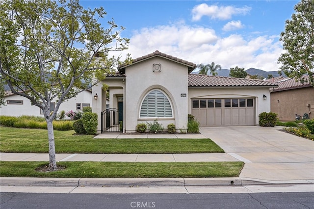 mediterranean / spanish-style house with a tile roof, a front yard, a garage, concrete driveway, and stucco siding