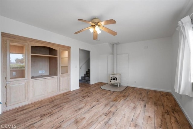259 Saint Andrews Way, Lompoc, CA 93436 - unfurnished room featuring a wood stove, a ceiling fan, light wood finished floors, and stairway