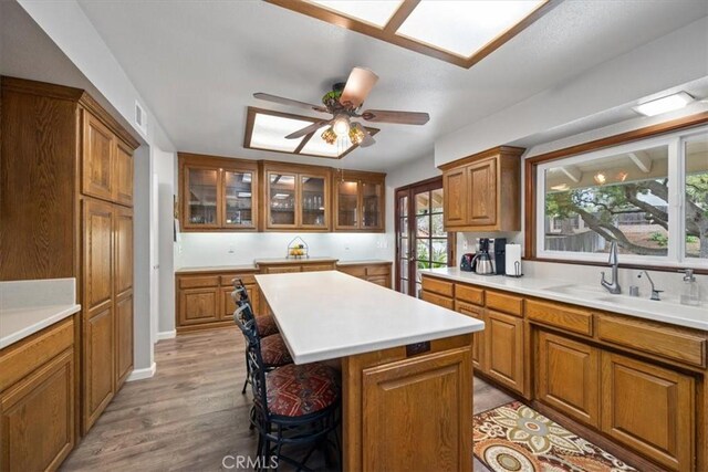 259 Saint Andrews Way, Lompoc, CA 93436 - kitchen featuring brown cabinets, a kitchen breakfast bar, a center island, light wood-style floors, and light countertops