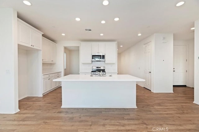 467 Daniella Way, Perris, CA 92570 - kitchen featuring appliances with stainless steel finishes, an island with sink, a sink, white cabinets, and recessed lighting