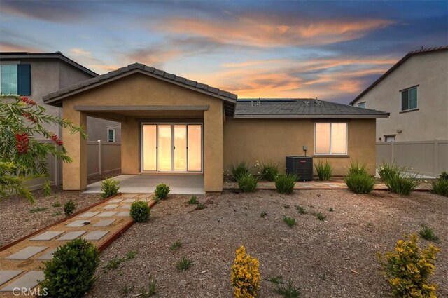 467 Daniella Way, Perris, CA 92570 - back of property at dusk featuring stucco siding, a patio, and central AC unit