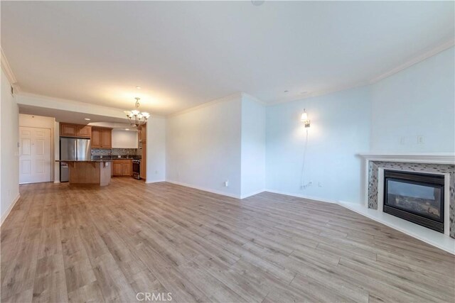 1437 Lomita Blvd Unit 227, Harbor City, CA 90710 - unfurnished living room with an inviting chandelier, ornamental molding, a glass covered fireplace, and light wood finished floors