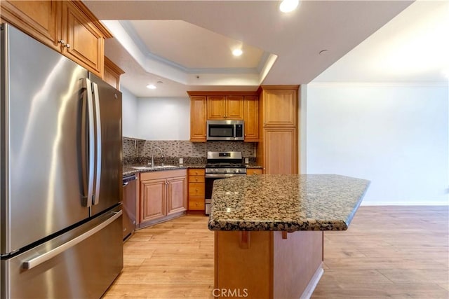 1437 Lomita Blvd Unit 227, Harbor City, CA 90710 - kitchen featuring light wood-style floors, a center island, tasteful backsplash, a sink, and appliances with stainless steel finishes