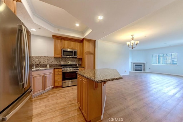 1437 Lomita Blvd Unit 227, Harbor City, CA 90710 - kitchen with ornamental molding, a breakfast bar, light wood-type flooring, tasteful backsplash, and appliances with stainless steel finishes