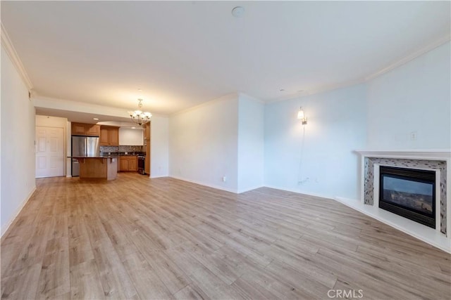 1437 Lomita Blvd Unit 227, Harbor City, CA 90710 - unfurnished living room with an inviting chandelier, ornamental molding, a glass covered fireplace, baseboards, and light wood finished floors