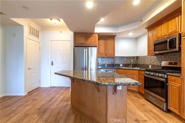 1437 Lomita Blvd Unit 227, Harbor City, CA 90710 - kitchen with brown cabinets, ornamental molding, stainless steel appliances, and a kitchen bar