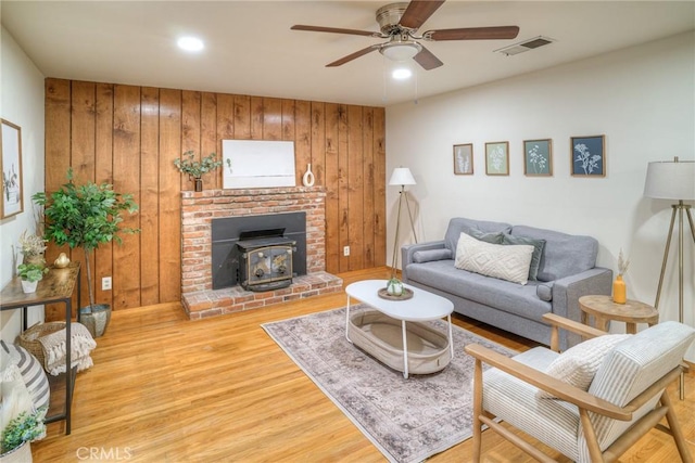 12 Linda Loma Dr, Oroville, CA 95966 - living area with a wood stove, wood walls, visible vents, ceiling fan, and wood finished floors