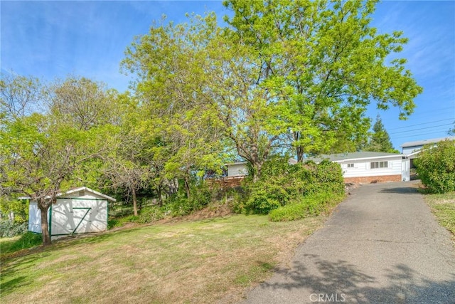 12 Linda Loma Dr, Oroville, CA 95966 - view of yard featuring driveway, a storage unit, and an outdoor structure