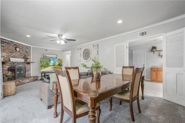 dining space with light colored carpet, visible vents, a ceiling fan, and crown molding