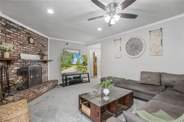 carpeted living room featuring visible vents, ceiling fan, recessed lighting, ornamental molding, and a brick fireplace