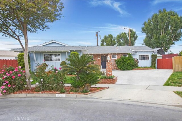 single story home with driveway, roof with shingles, board and batten siding, and fence