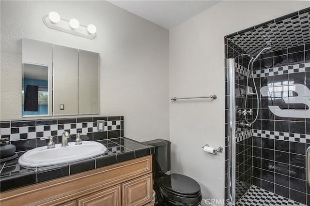 full bath with toilet, a stall shower, backsplash, and vanity