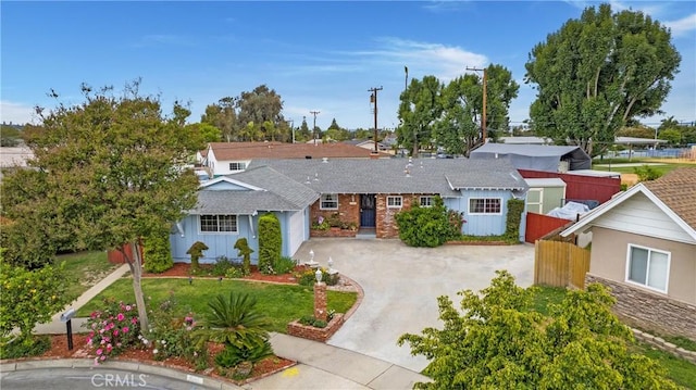 ranch-style home with driveway, fence, roof with shingles, and a garage