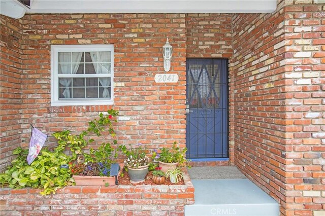 property entrance featuring brick siding