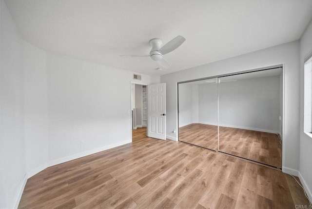 unfurnished bedroom with a closet, light wood-type flooring, baseboards, visible vents, and a ceiling fan