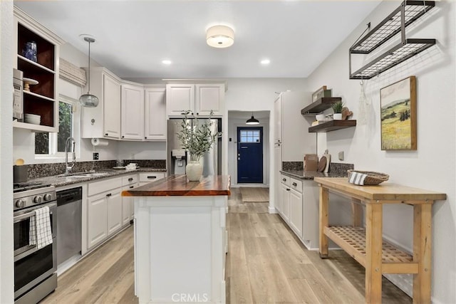 4338 Beagle St, Los Angeles, CA 90032 - kitchen featuring open shelves, butcher block countertops, a sink, appliances with stainless steel finishes, and light wood finished floors