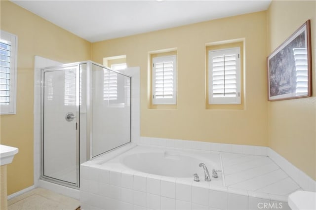 full bathroom with a healthy amount of sunlight, a shower stall, and a garden tub