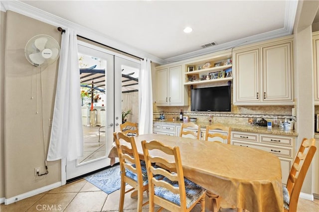 dining room featuring light tile patterned floors, crown molding, visible vents, baseboards, and french doors