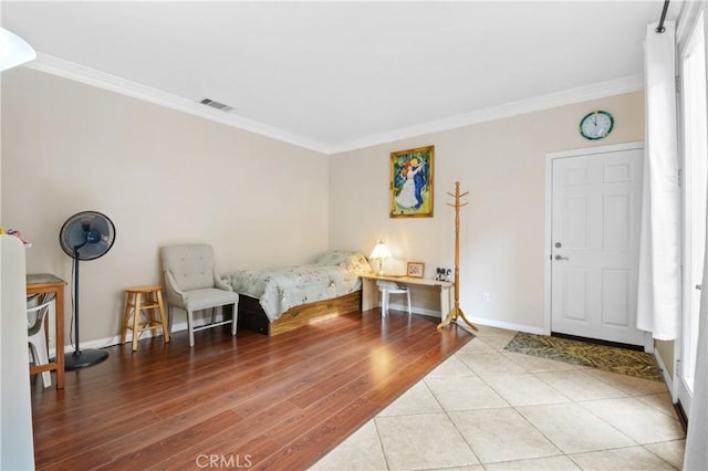 bedroom with baseboards, visible vents, and ornamental molding