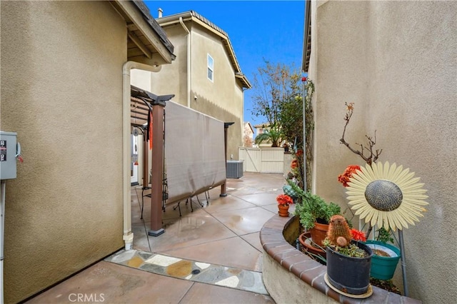 view of property exterior with fence, a patio, a gate, stucco siding, and central AC