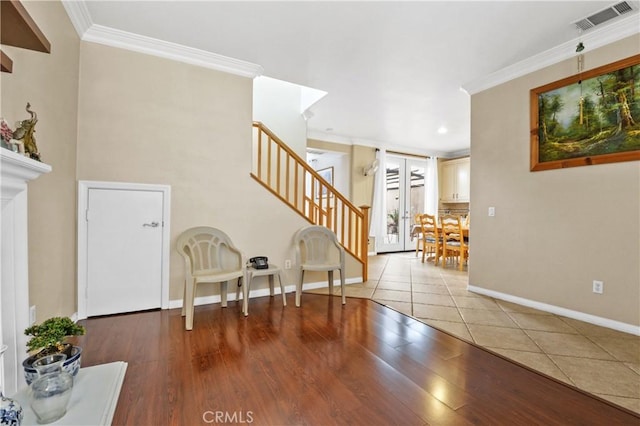 entrance foyer featuring wood finished floors, stairway, ornamental molding, baseboards, and visible vents