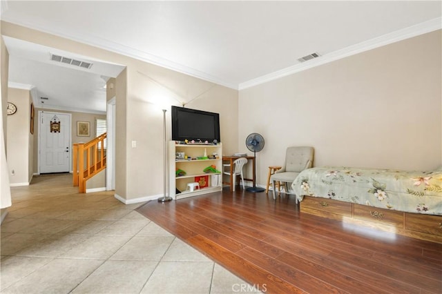 bedroom featuring crown molding, visible vents, light tile patterned floors, and baseboards