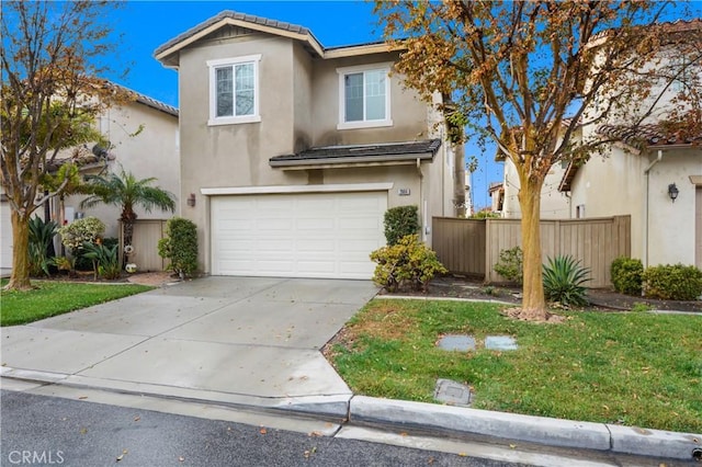 traditional home featuring a front yard, a garage, driveway, stucco siding, and fence