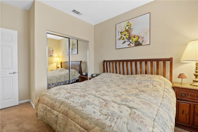 carpeted bedroom featuring a closet, visible vents, and baseboards