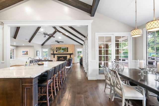 5135 Island Forest Pl, Westlake Village, CA 91362 - dining space featuring vaulted ceiling with beams, a ceiling fan, wainscoting, and a stone fireplace
