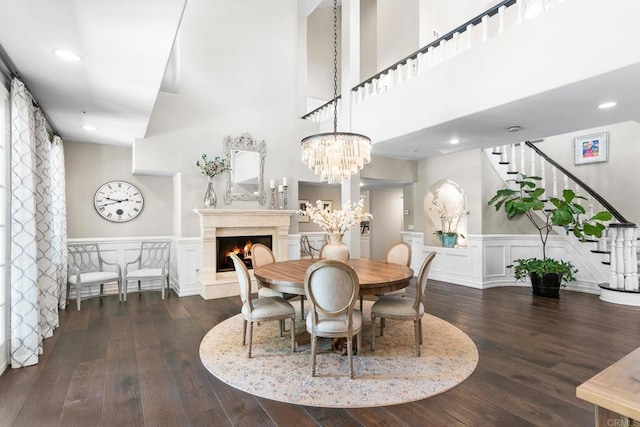 5135 Island Forest Pl, Westlake Village, CA 91362 - dining area with a fireplace, wainscoting, hardwood / wood-style flooring, a decorative wall, and stairs