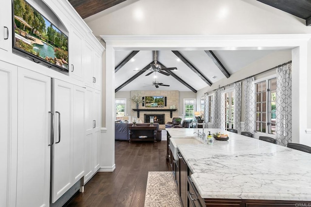 5135 Island Forest Pl, Westlake Village, CA 91362 - kitchen with a kitchen island, a fireplace, white cabinets, open floor plan, and vaulted ceiling with beams