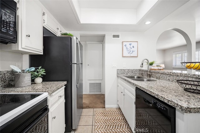 kitchen featuring a sink, white cabinets, black appliances, and visible vents