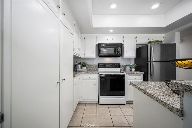 kitchen featuring freestanding refrigerator, light tile patterned flooring, black microwave, electric range oven, and white cabinets