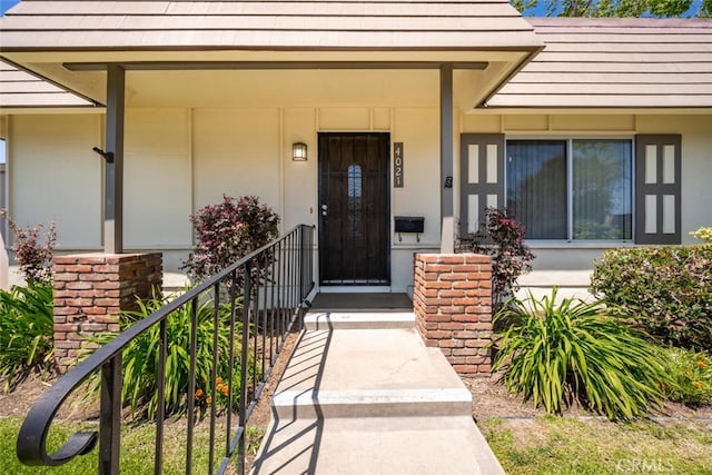 entrance to property with stucco siding and covered porch