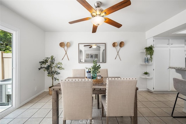 dining room featuring a ceiling fan, baseboards, and light tile patterned floors