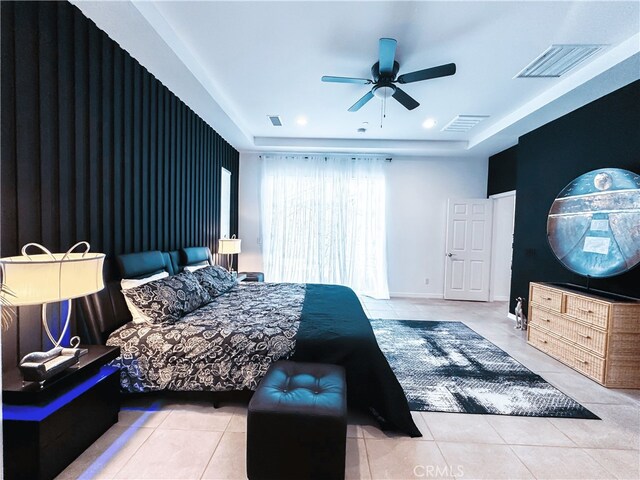 bedroom featuring tile patterned floors, visible vents, and a raised ceiling