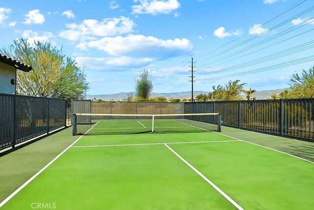 view of tennis court featuring fence and community basketball court